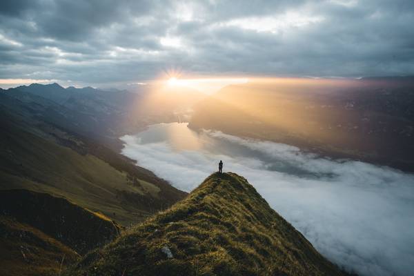 Ein Mensch steht auf einem Berg und schaut auf den Horizont