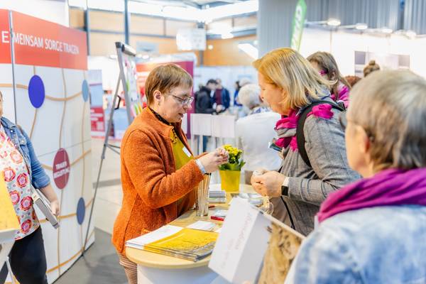 Mehrere Frauen unterhalten sich an einem Messestand