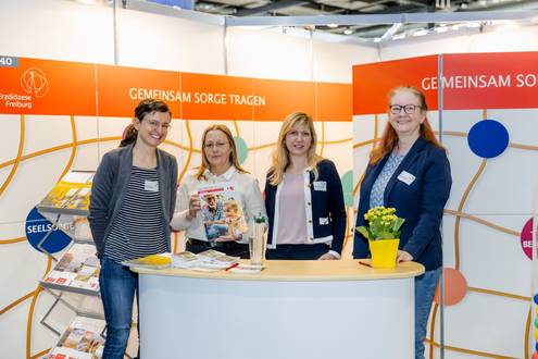 Vier Frauen stehen hinter einem Messestand